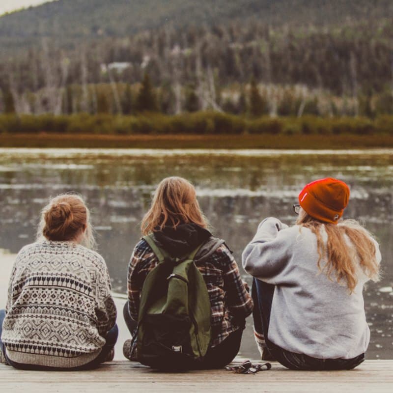 Practitioners sitting together at the water's edge, unhurried